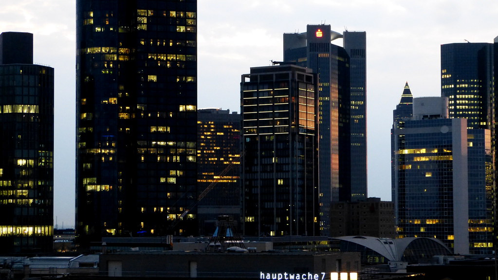 Frankfurter Skyline mit beleuchteten Hochhäusern am Abend.