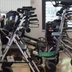 Mehrere Rollatoren stehen in einem Innenraum nebeneinander.