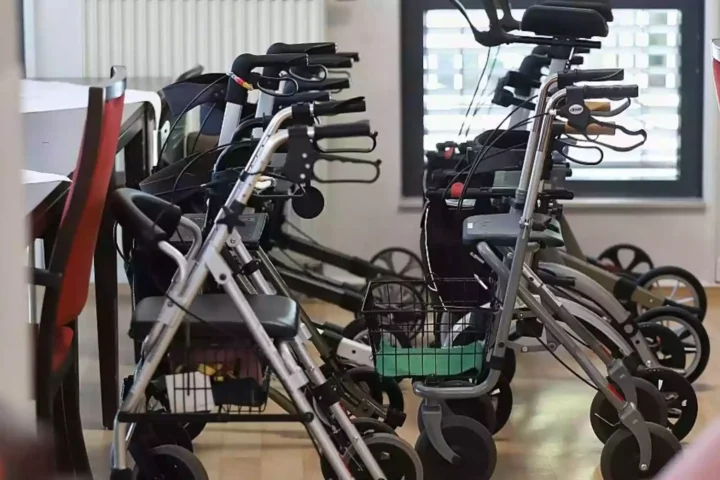 Mehrere Rollatoren stehen in einem Innenraum nebeneinander.