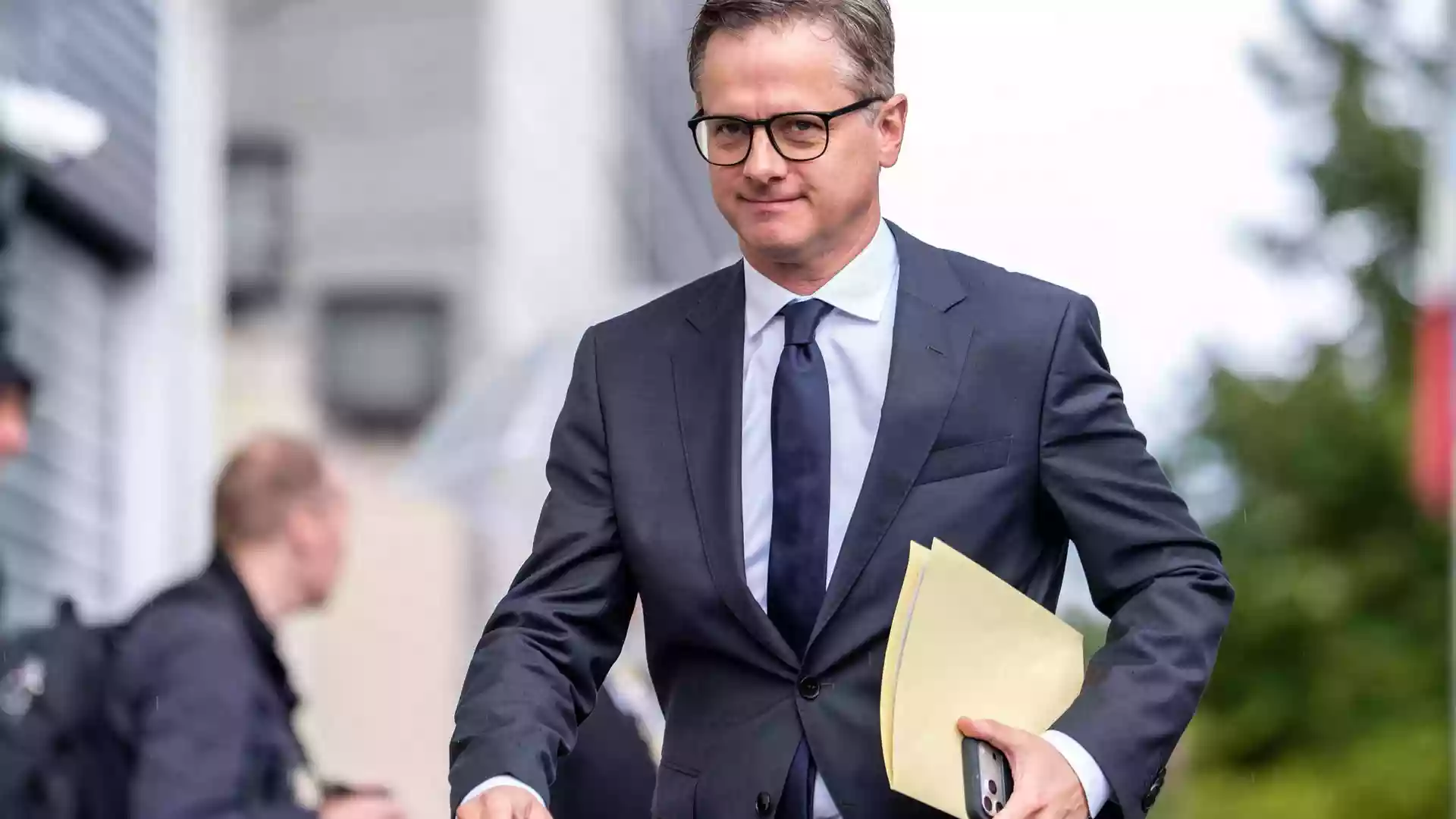 Bundesregierung setzt 13-köpfige Kommission für Pflegereform ein 1 Ein Mann im dunklen Anzug mit Brille hält eine Aktenmappe in der Hand.