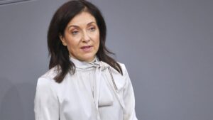 Katherina Reiche vor grauem Hintergrund bei einem öffentlichen Auftritt.