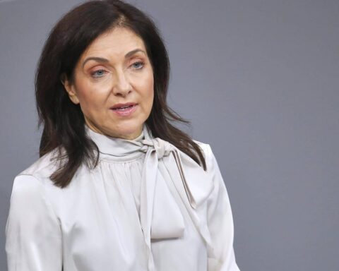 Katherina Reiche vor grauem Hintergrund bei einem öffentlichen Auftritt.