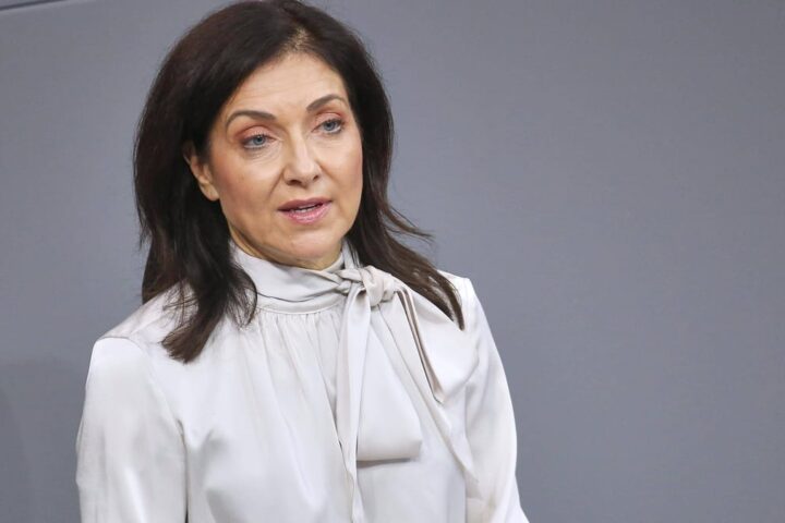 Katherina Reiche vor grauem Hintergrund bei einem öffentlichen Auftritt.