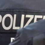 Rückenansicht von Polizisten mit der Aufschrift „POLIZEI“ auf der Uniform.