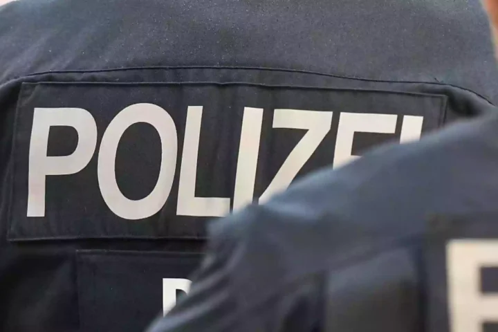Rückenansicht von Polizisten mit der Aufschrift „POLIZEI“ auf der Uniform.
