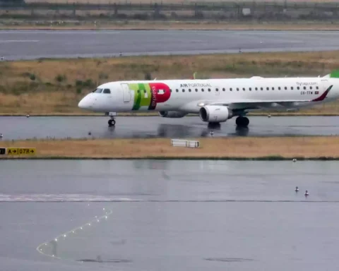 Ein TAP-Air-Portugal-Flugzeug rollt auf einer nassen Start- und Landebahn.