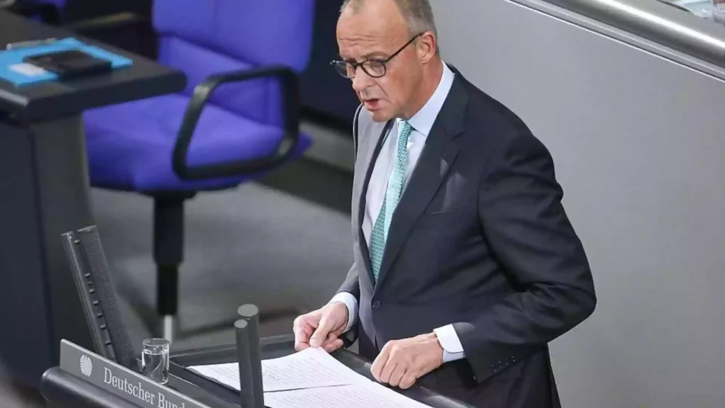 Friedrich Merz steht am Rednerpult im Deutschen Bundestag und blickt auf Unterlagen.