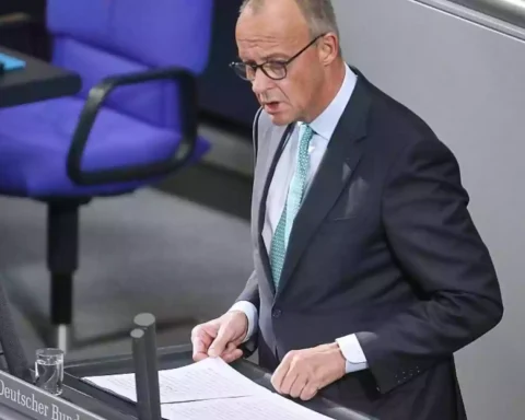 Friedrich Merz steht am Rednerpult im Deutschen Bundestag und blickt auf Unterlagen.