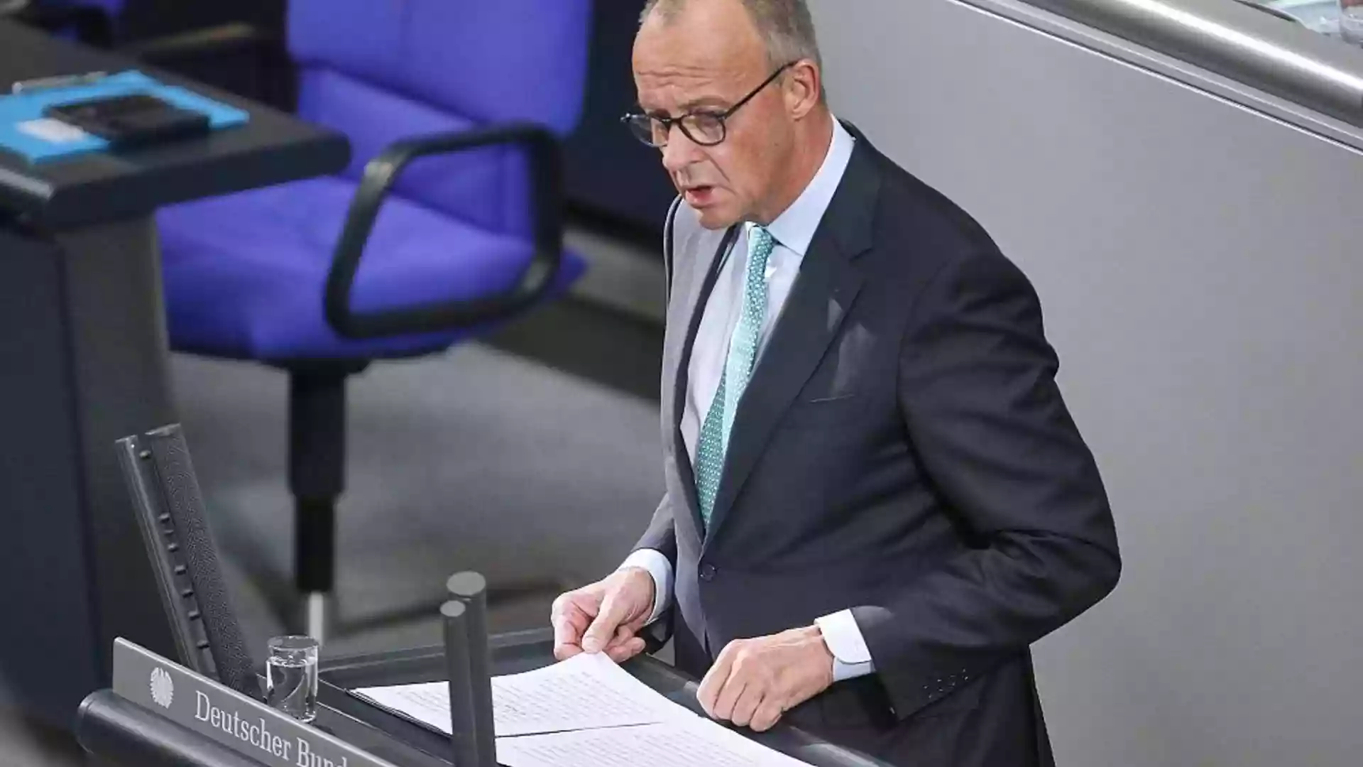 Friedrich Merz steht am Rednerpult im Deutschen Bundestag und blickt auf Unterlagen.