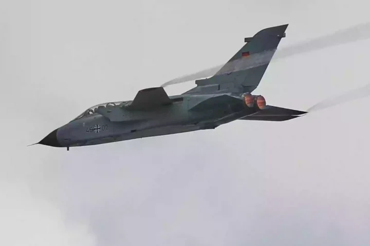 Ein deutscher Kampfjet fliegt vor hellem Himmel.