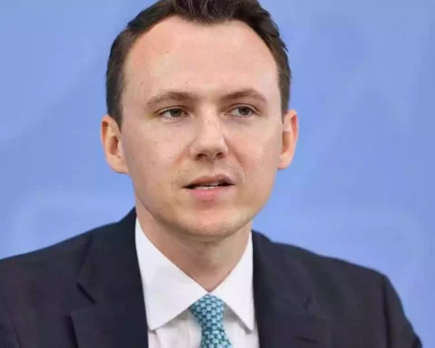 Pascal Reddig in dunklem Anzug vor blauem Hintergrund.