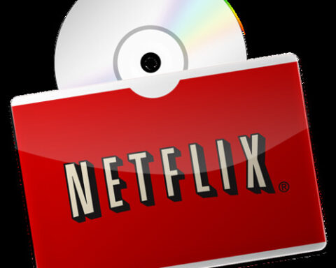 Rote Netflix-Hülle vor einer CD/DVD auf schwarzem Hintergrund.