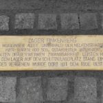Gedenkplakette am Boden mit der Inschrift zum Lager Finkenberg und zum Zwangsarbeitseinsatz bei den Drägerwerken.