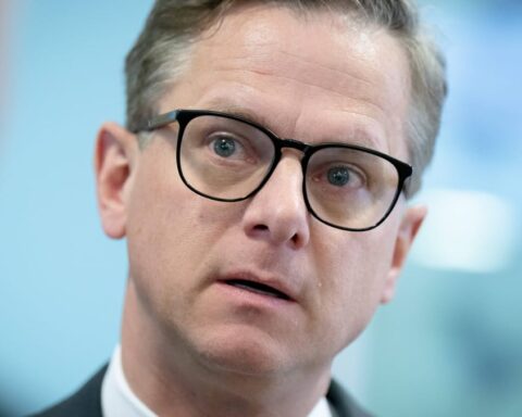 Carsten Linnemann in Nahaufnahme mit Brille vor blauem Hintergrund.