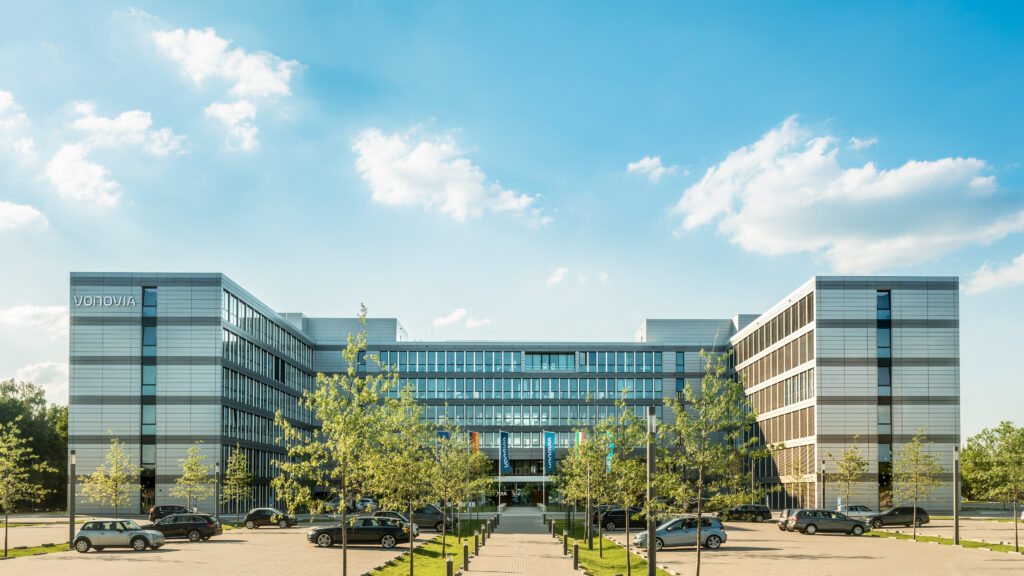 Außenansicht eines modernen Vonovia-Verwaltungsgebäudes bei sonnigem Himmel.