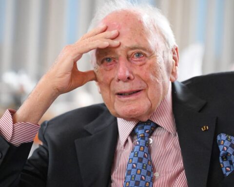 Reinhold Würth sitzt in einem Anzug und hält die Hand an die Stirn.