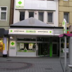 Außenansicht einer DocMorris-Apotheke in einer Fußgängerzone.