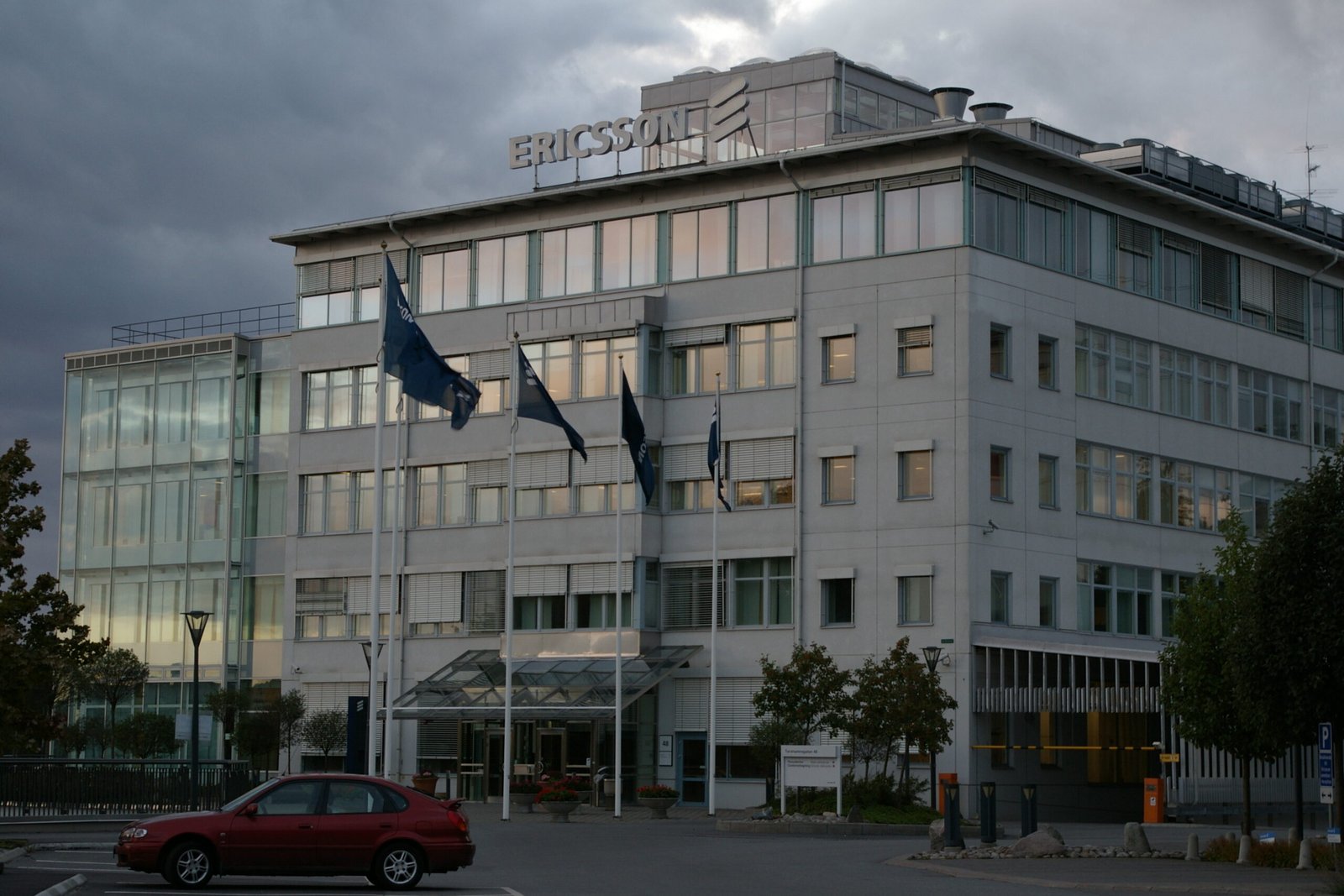 Ericsson-Aktie springt nach Quartalszahlen um 8,7 Prozent nach oben 1 Ericsson-Firmengebäude mit Logo auf dem Dach unter bewölktem Himmel.