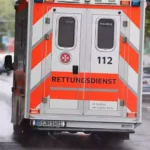 Rückseite eines Rettungswagens mit der Aufschrift „Rettungsdienst“ auf einer Straße in Berlin.