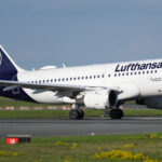Eine Lufthansa-Maschine rollt auf einer Startbahn mit sichtbarem Lufthansa-Logo am Heck.