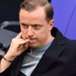 Adis Ahmetovic sitzt im Bundestag und blickt nachdenklich nach vorn.