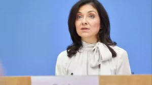 Katherina Reiche steht vor blauem Hintergrund an einem Rednerpult.