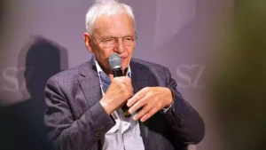 Götz Aly spricht mit einem Mikrofon bei einer Veranstaltung.