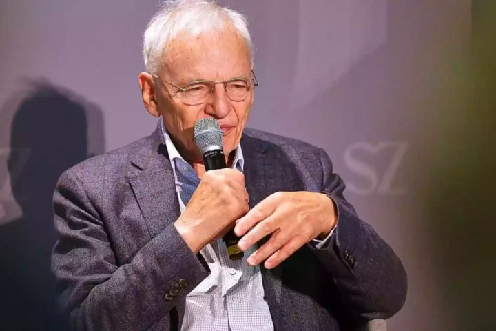 Götz Aly spricht mit einem Mikrofon bei einer Veranstaltung.