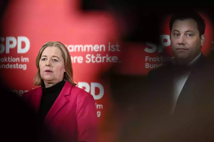 Zwei SPD-Politiker vor rotem Parteihintergrund mit SPD-Logo.