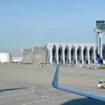 Lufthansa-Flugzeug auf dem Vorfeld am Flughafen Frankfurt mit Tower und Terminalgebäuden im Hintergrund.