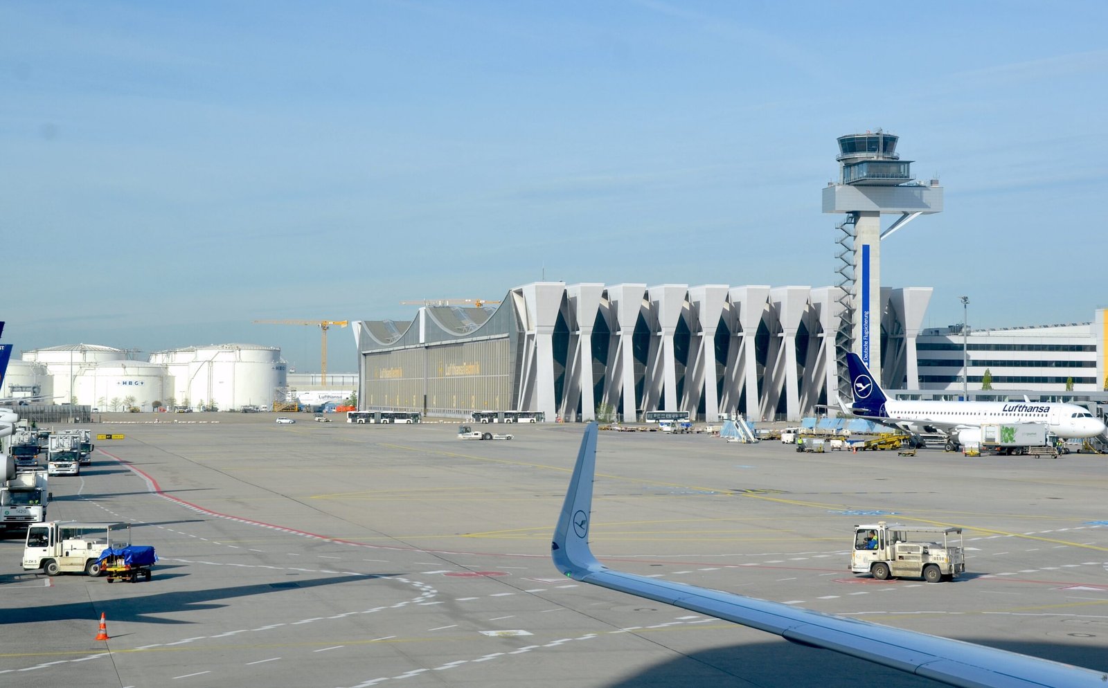 Lufthansa-Flugzeug auf dem Vorfeld am Flughafen Frankfurt mit Tower und Terminalgebäuden im Hintergrund.