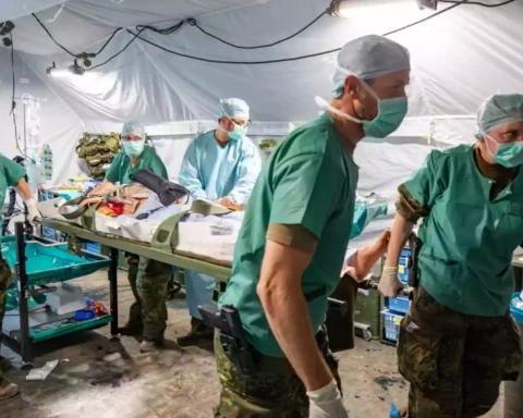 Sanitätspersonal arbeitet in einem provisorischen Feldlazarett mit Trage und medizinischer Ausrüstung.