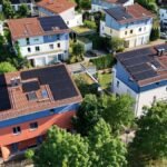 Luftaufnahme von Wohnhäusern mit Solaranlagen auf den Dächern in einem Wohngebiet.
