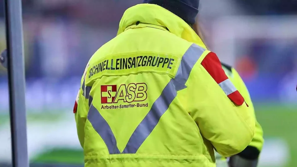 Rückansicht einer Person in gelber ASB-Einsatzjacke mit reflektierenden Streifen.