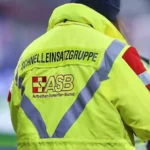 Rückansicht einer Person in gelber ASB-Einsatzjacke mit reflektierenden Streifen.