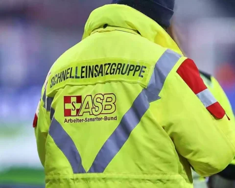 Rückansicht einer Person in gelber ASB-Einsatzjacke mit reflektierenden Streifen.