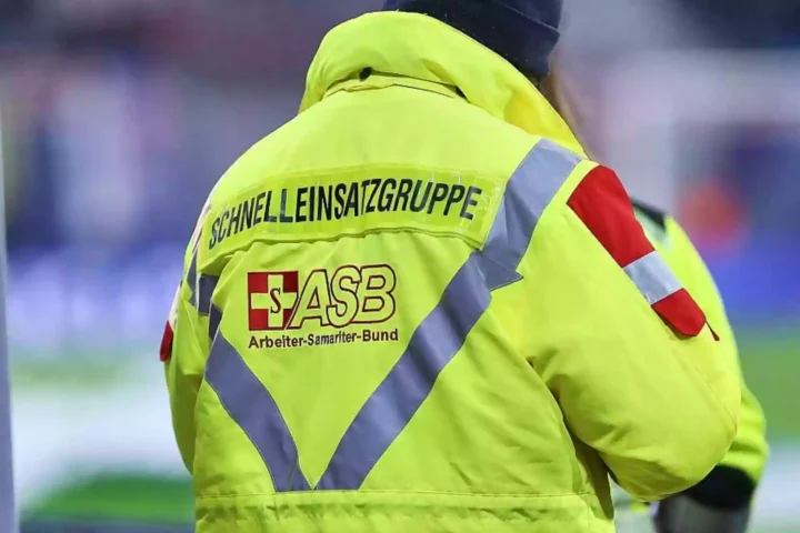 Rückansicht einer Person in gelber ASB-Einsatzjacke mit reflektierenden Streifen.
