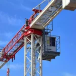 Baukran vor blauem Himmel auf einer Baustelle.