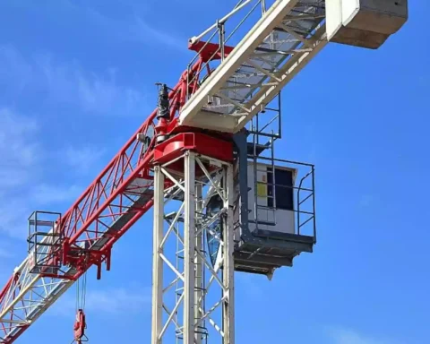 Baukran vor blauem Himmel auf einer Baustelle.