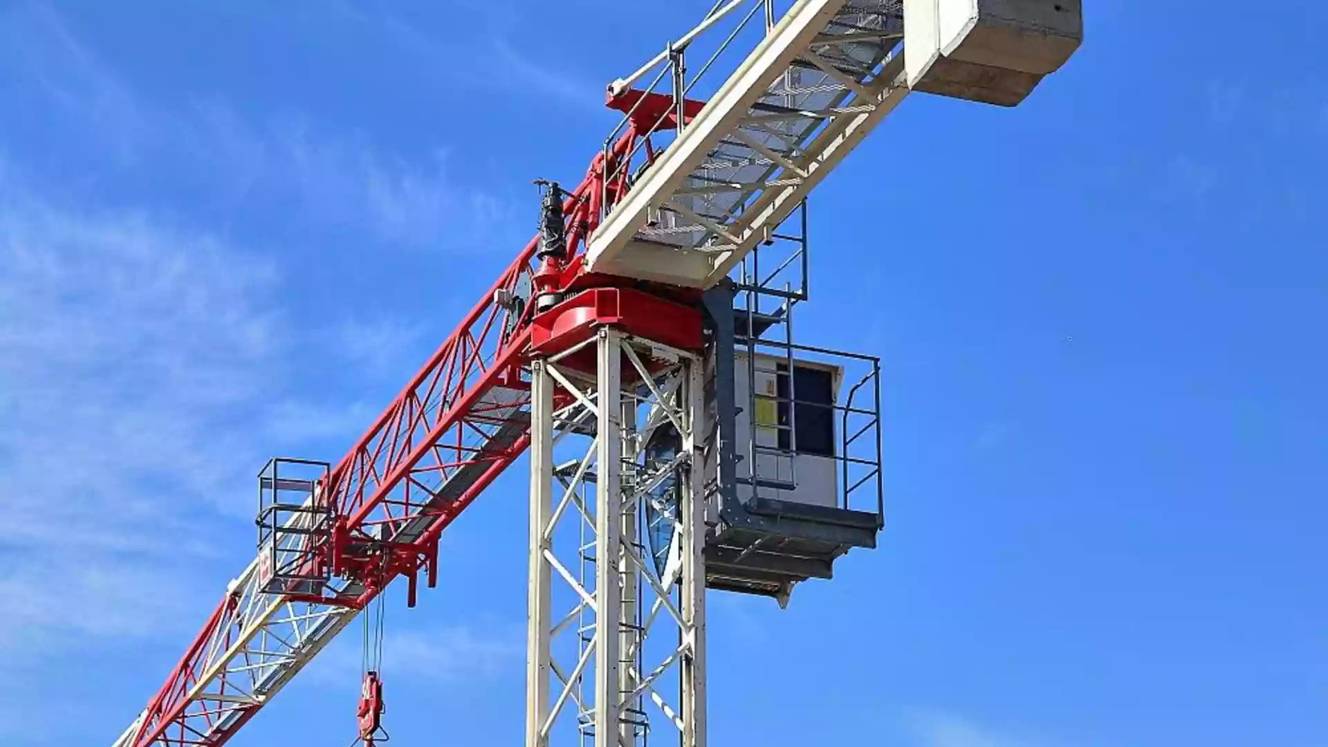 Baukran vor blauem Himmel auf einer Baustelle.