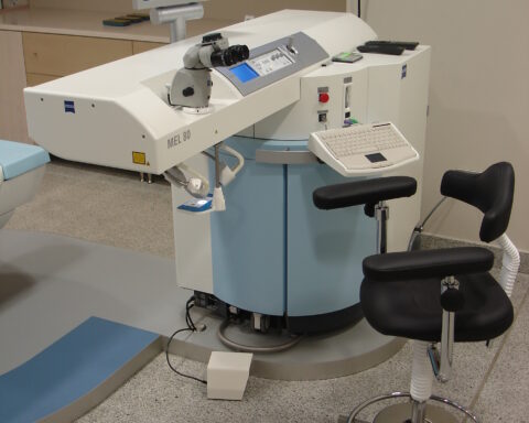 Ein Carl-Zeiss-Meditec-Lasergerät in einem Behandlungsraum mit Steuerkonsole, Monitor und Patientenstuhl.