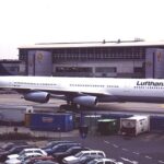 Lufthansa-Flugzeug auf dem Vorfeld vor einem Flughafengebäude.
