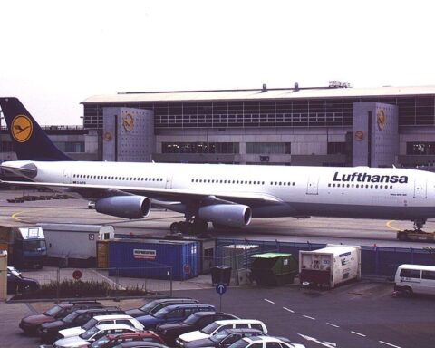 Lufthansa-Flugzeug auf dem Vorfeld vor einem Flughafengebäude.