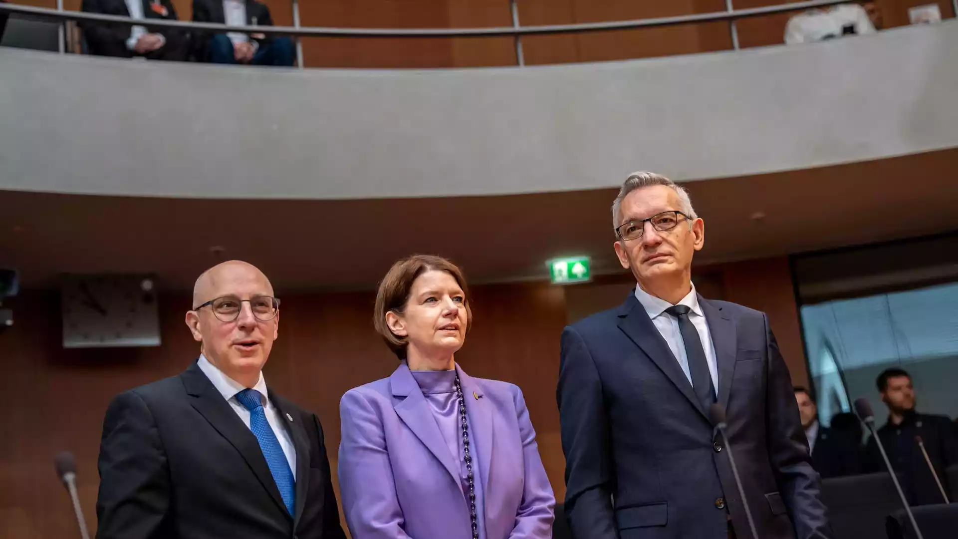 Jäger warnt vor russischem Schattenkrieg gegen Deutschland 1 Drei Personen in Anzügen und einem lilafarbenen Blazer stehen in einem Sitzungssaal des Bundestags.