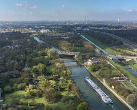 Luftaufnahme eines Industrie- und Wohngebiets mit Kanal, Straßen und Fabrikanlagen im Ruhrgebiet.