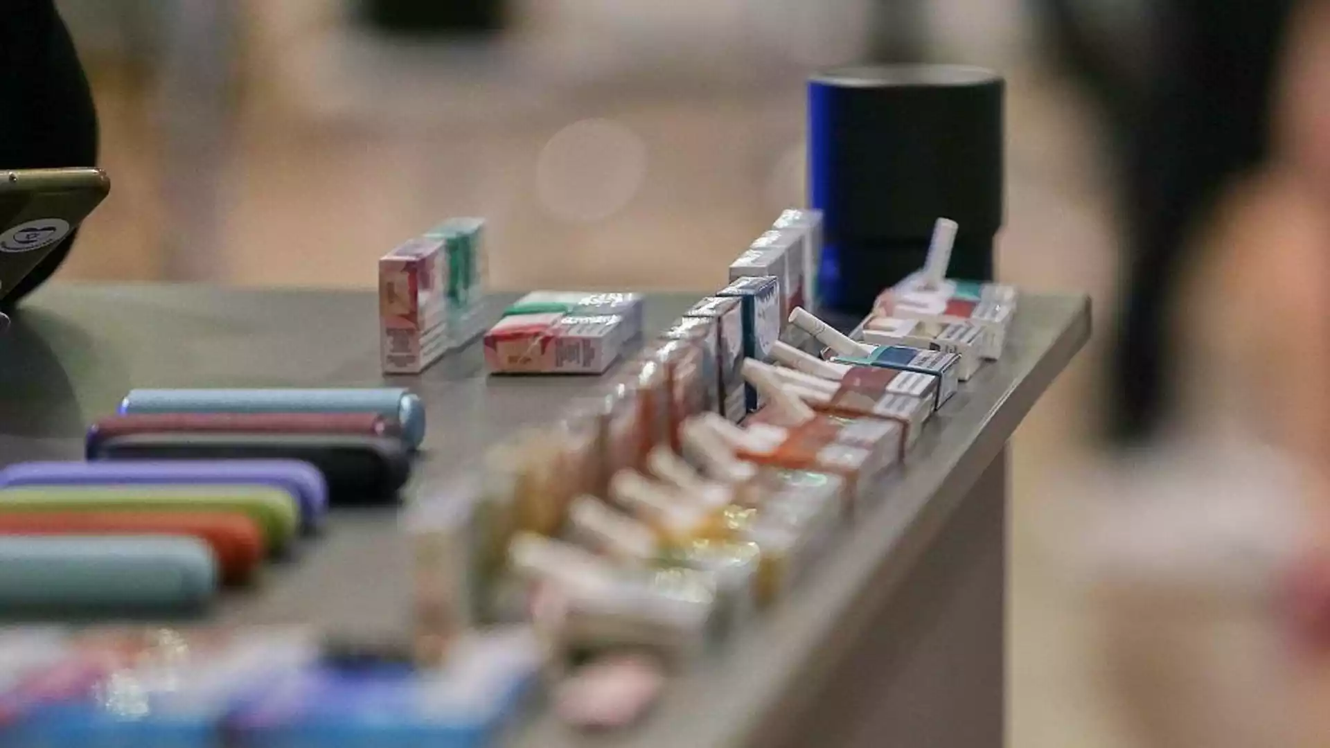 Tabaksteuer soll Zigarettenkonsum in Deutschland um 25 Prozent senken 1 Zigarettenpackungen und E-Zigaretten auf einem Tisch in einer Verkaufsumgebung.