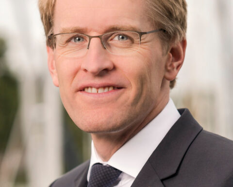 Porträt von Schleswig-Holsteins Ministerpräsident Daniel Günther im dunklen Anzug und mit Brille.
