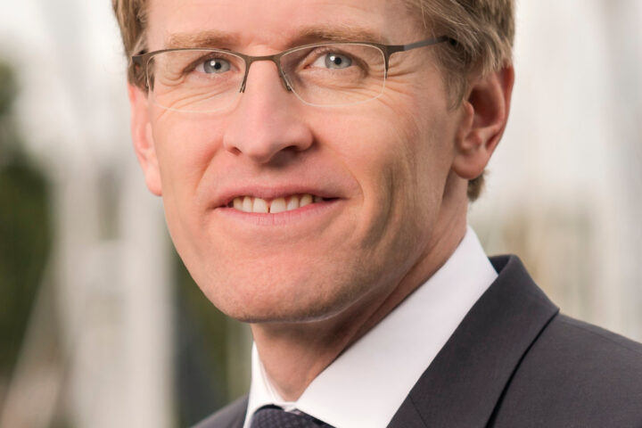 Porträt von Schleswig-Holsteins Ministerpräsident Daniel Günther im dunklen Anzug und mit Brille.